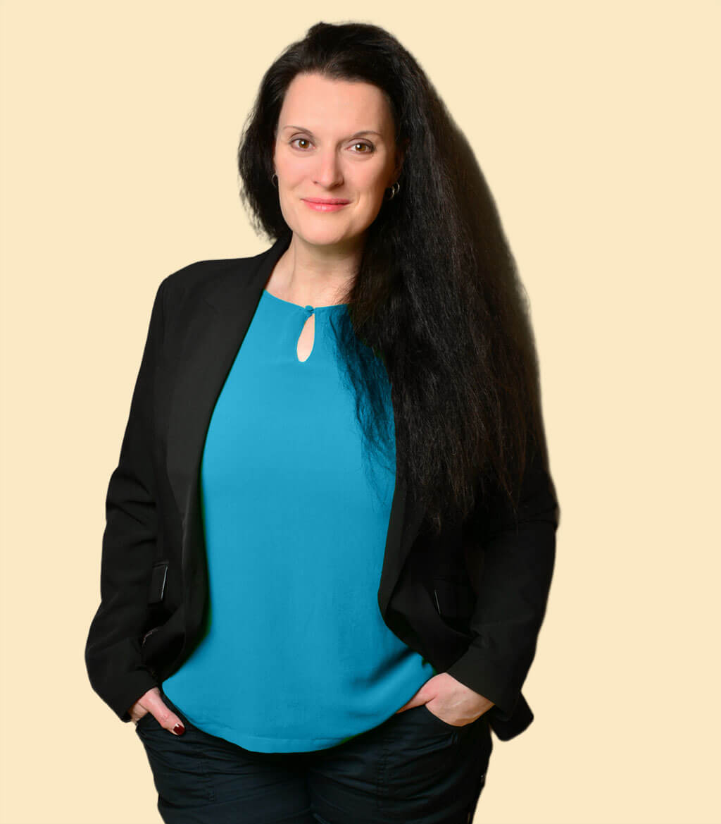 Cornelia Leclerc steht lächelnd mit den Händen in den Hosentaschen als Portrait für Emotionscoaching und Resilienzcoaching