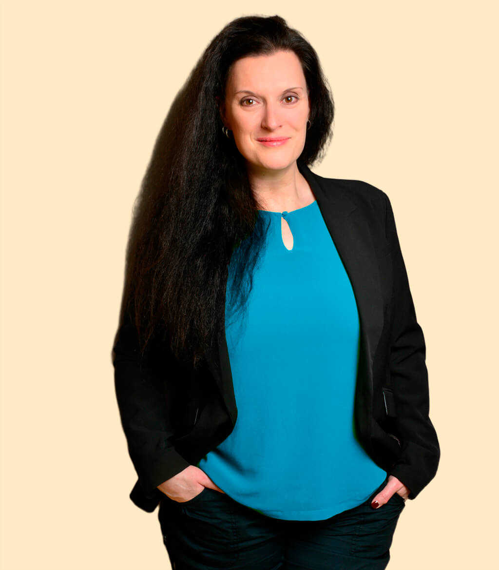 Cornelia Leclerc steht lächelnd mit den Händen in den Hosentaschen im Über mich Bereich der Seite Ressourcenaktivierung bei Stress
